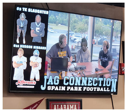 A TV screen shows a football game with two men talking. AI generated content