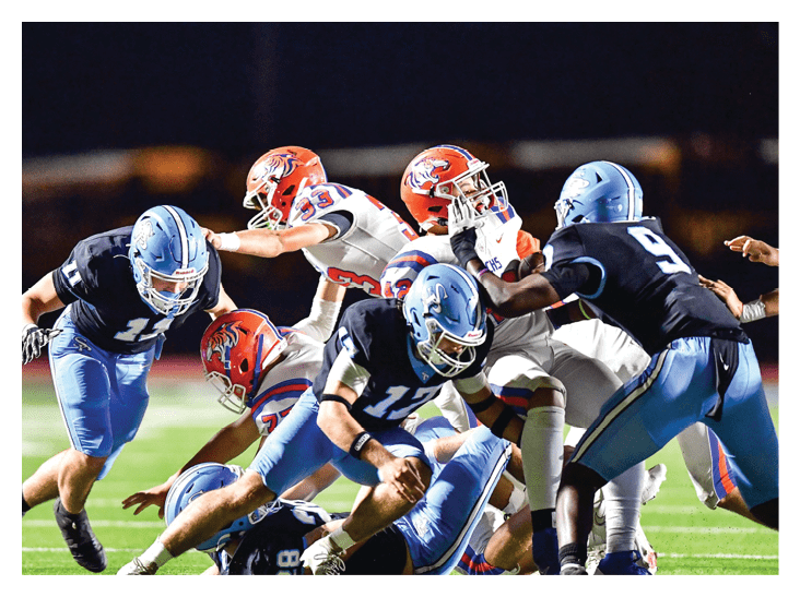 A group of football players in blue and white uniforms are playing a game on a field. AI generated content