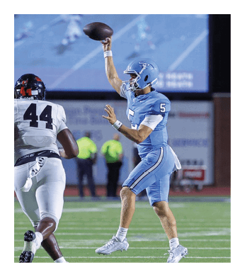 A football player in a blue jersey throws a football on a field. AI generated content