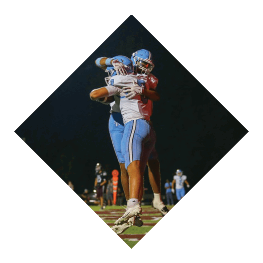 Two football players jumping in the air to catch a ball. AI generated content