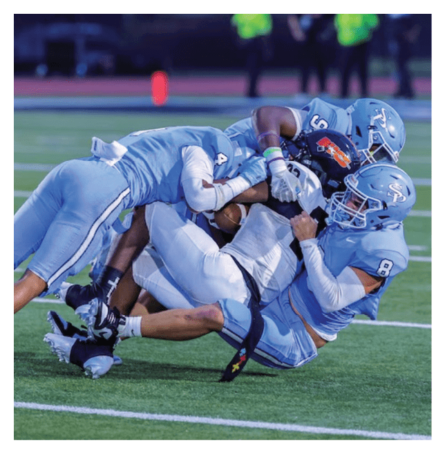 A group of football players are tackling each other on the field. AI generated content