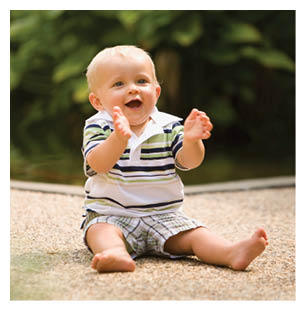 A baby is sitting on the ground wearing a striped shirt and shorts. AI generated content