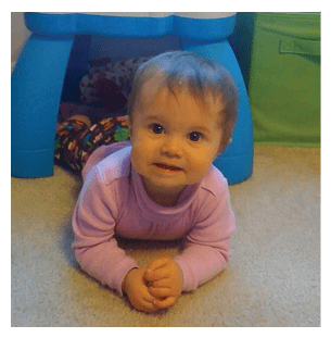 A baby is laying on the floor, smiling and looking at the camera. AI generated content