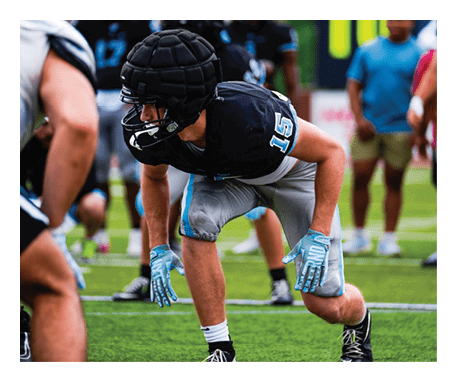 A football player in a black helmet and grey uniform is crouched on the field. AI generated content