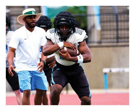 A football player in a black helmet and blue jersey is running with a football. AI generated content