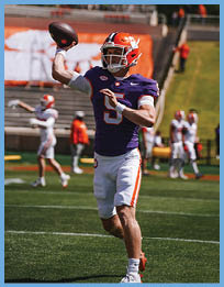 A football player in a purple jersey with the number 5 on it is throwing a football on a field. AI generated content