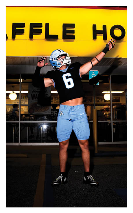 A man wearing a football jersey stands in front of a Waffle House sign. AI generated content