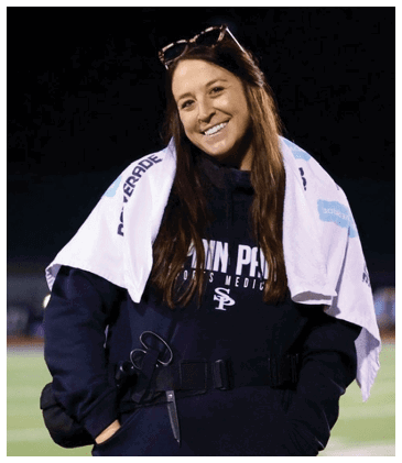 A woman wearing a black and white jacket stands on a field. AI generated content