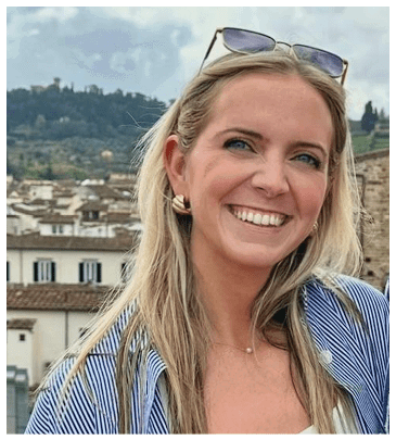 A woman wearing sunglasses and a blue shirt is smiling for the camera. AI generated content