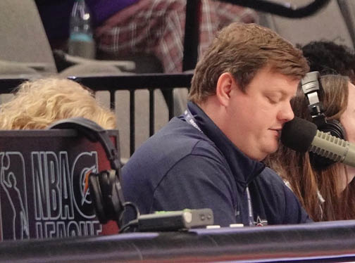 A group of people are sitting in front of microphones, possibly participating in a radio show or podcast. AI generated content