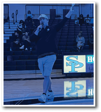 A man is standing on a basketball court holding a microphone. AI generated content