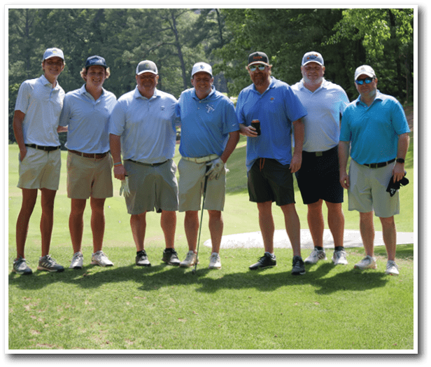 A group of men wearing golf attire pose for a picture on a golf course. AI generated content
