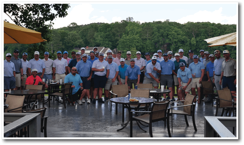 A group of men wearing blue shirts and white hats pose for a photo on a patio. AI generated content