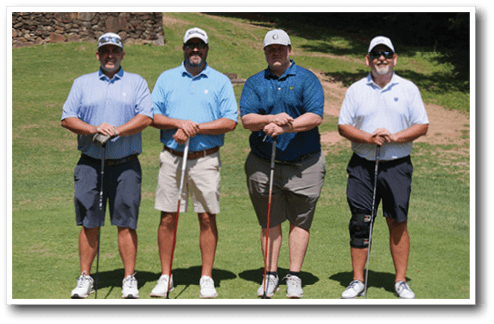 Four men standing on a golf course, each holding a golf club. AI generated content