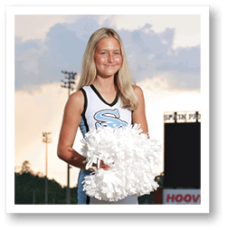 A cheerleader in a blue and white uniform stands on a field holding a white pom pom. AI generated content