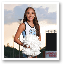 A cheerleader in a blue and white uniform stands on a football field. AI generated content
