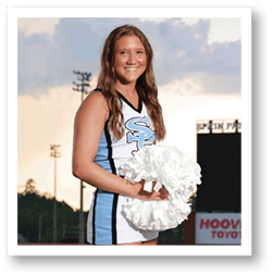 A cheerleader in a blue and white uniform stands on a football field holding a pom pom. AI generated content