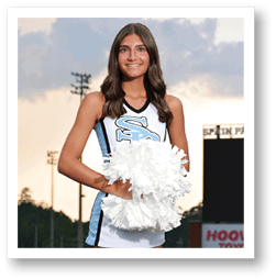A cheerleader in a blue and white uniform stands on a football field. AI generated content