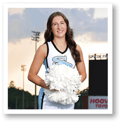 A cheerleader in a blue and white uniform stands on a football field holding a pom pom. AI generated content
