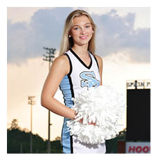 A cheerleader in a blue and white uniform stands on a football field holding a pom pom. AI generated content