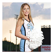 A cheerleader in a blue and white uniform stands on a football field. AI generated content