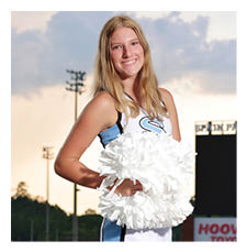 A woman in a cheerleading outfit stands on a field. AI generated content
