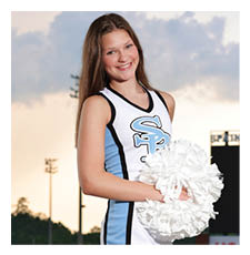 A cheerleader in a blue and white uniform stands on a football field holding a pom pom. AI generated content