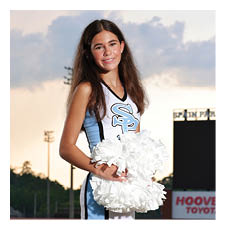 A cheerleader in a blue and white uniform stands on a football field. AI generated content