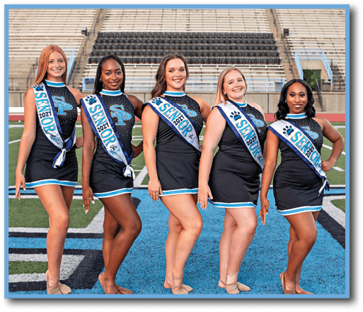 Five cheerleaders in uniforms pose for a photo on a football field. AI generated content