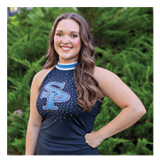 A woman in a cheerleading outfit poses for a picture. AI generated content