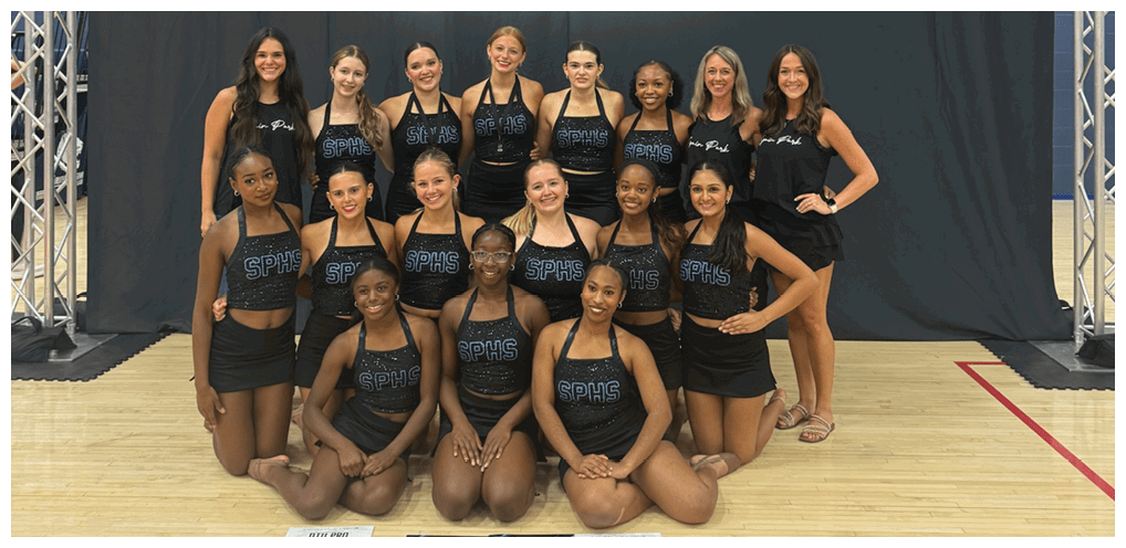 A group of women pose for a photo in front of a banner that says “Dance Team Union Summer Camp." AI generated content