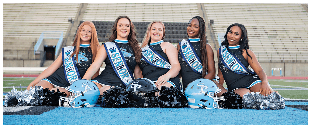 A group of cheerleaders pose for a picture on the field. AI generated content