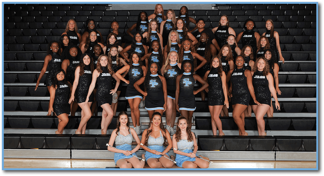 A group of cheerleaders pose for a photo in front of a bleacher. AI generated content