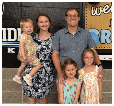 A family poses for a photo in front of a sign that reads “Welcome to Mr. Proud Park." AI generated content