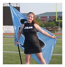 A woman in a black dress holds a flag on a grassy field. AI generated content