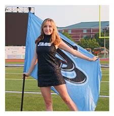 A woman in a black dress holds a blue flag on a football field. AI generated content