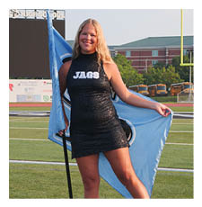 A woman in a black and blue dress stands on a football field holding a flag. AI generated content