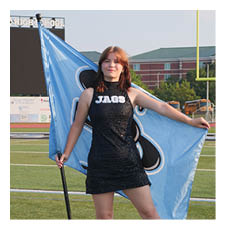 A woman in a black and blue shirt holds a flag on a football field. AI generated content