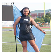A woman in a black dress is holding a blue flag and standing on a field. AI generated content