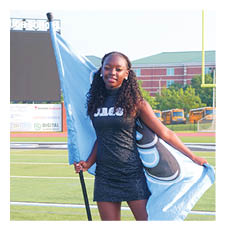 A woman in a black and blue dress holds a flag on a football field. AI generated content