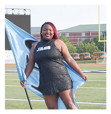 A woman in a blue dress stands on a football field holding a blue flag. AI generated content