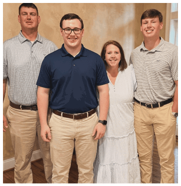 A man, woman, and two men pose for a picture. The woman is wearing a white dress. AI generated content