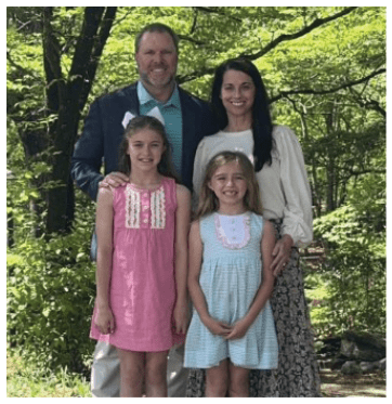 A family poses for a photo in front of a tree. AI generated content