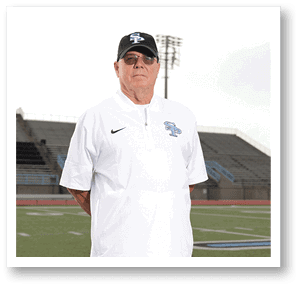 A man wearing a white shirt and a black hat stands on a football field. AI generated content
