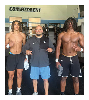Three men are standing in a gym, posing for a picture. One man is wearing a gray shirt, while the other two are shirtless. They are all smiling for the camera. AI generated content