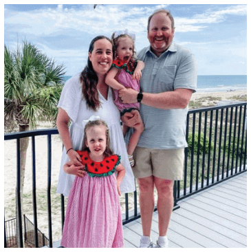 A family poses for a photo on a deck overlooking the ocean. AI generated content