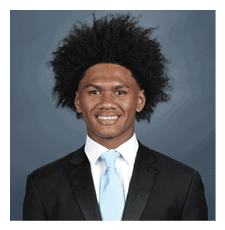 A young man wearing a suit and tie is smiling for the camera. AI generated content