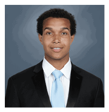 A young man wearing a suit and tie is smiling for the camera. AI generated content