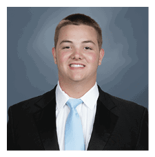 A man wearing a suit and tie smiles for the camera. AI generated content