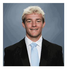 A young man wearing a suit and tie is smiling for the camera. AI generated content